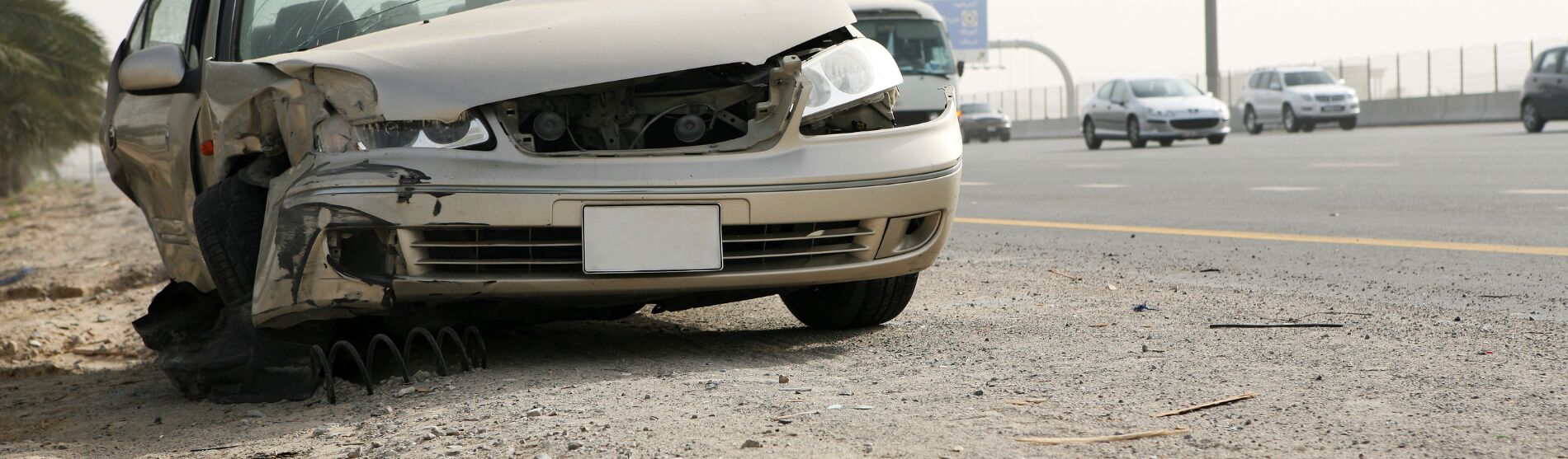 Car with front-end collision damage at the roadside